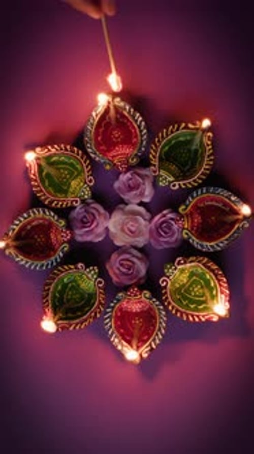 Diwali oil lamps being lit in dark setting