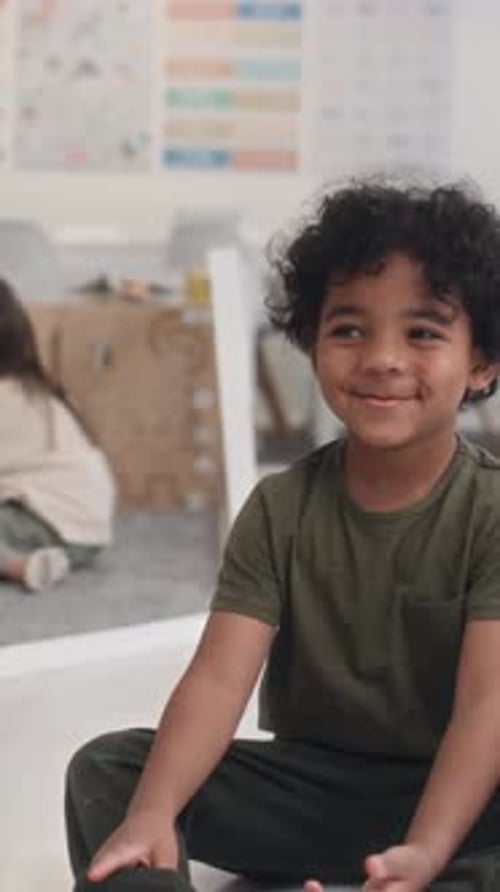 Smiling Boy Sits in Classroom With Friend
