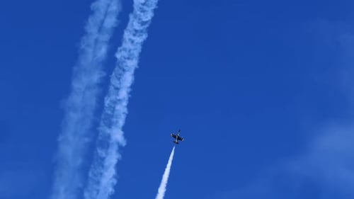 Aircraft Flying Upwards Near Vertical Vapor Trail Accentuating Flight Path Against Blue Sky Backdrop