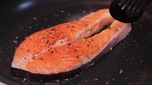 Salmon cooking in a hot frying pan