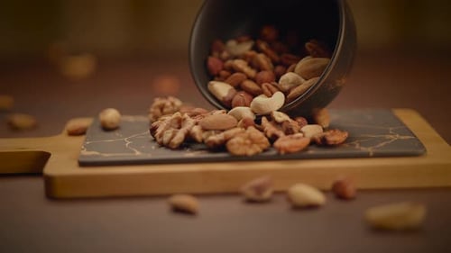 Mixed Nuts Spill onto a Cutting Board