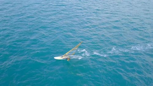 Aerial footage of High speed wind surfer riding the mediterranean waves
