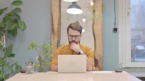 Man Working on Laptop in Modern Office