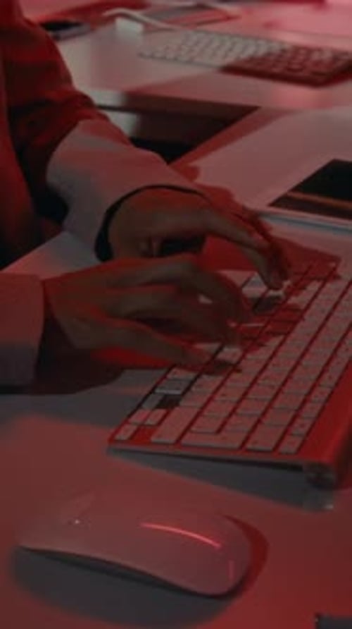 Woman Typing on Computer in Dark Office