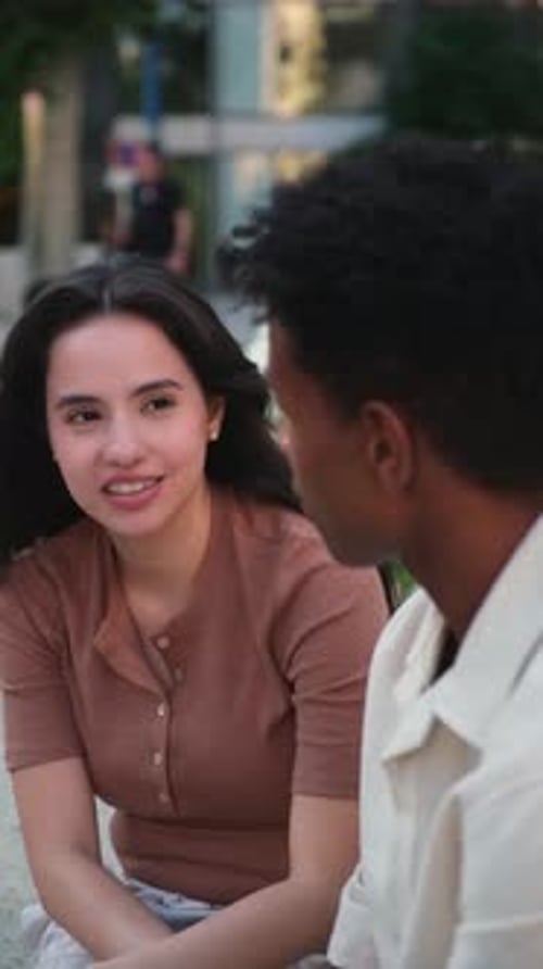 Young multi ethnic couple chatting and laughing together outdoors