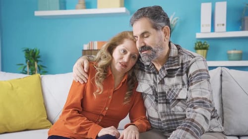 Affectionate Couple Conversing and Embracing on Sofa