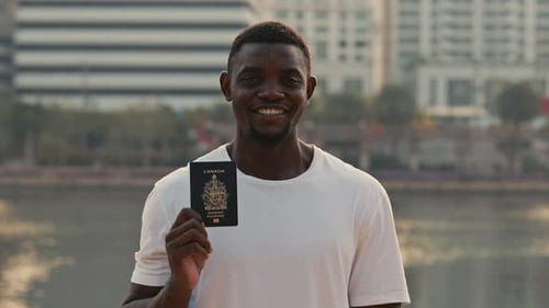 Portrait of Man Showing Passport of Canada with Smile Looking at Camera