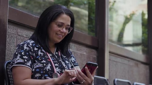 Of Cheerful Nurse Using Phone in Bus Stop