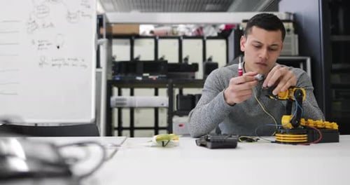 Junger Erwachsener arbeitet an Robotik