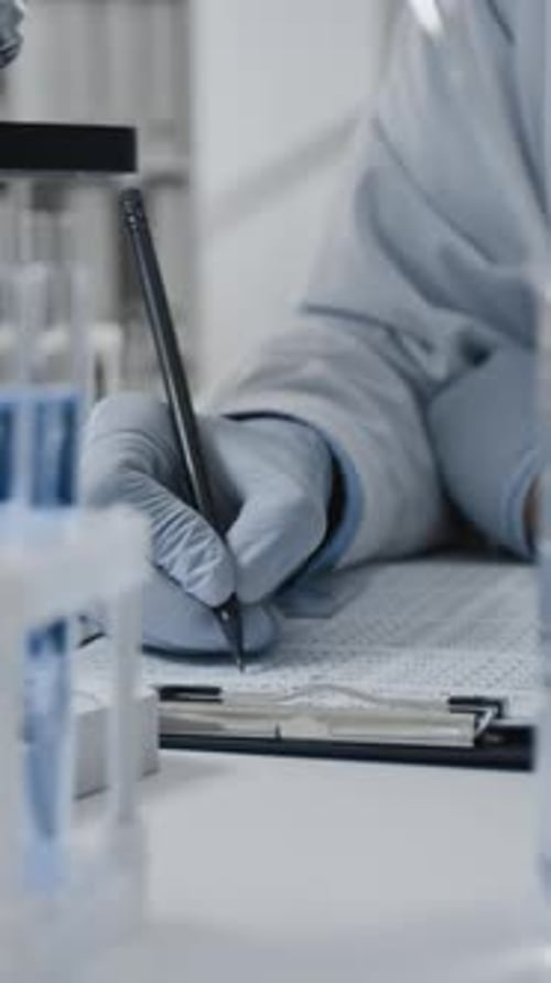Scientist Records Data in a Laboratory Setting