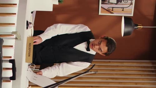 Hotel Reception With Man Checking In With Snowboard