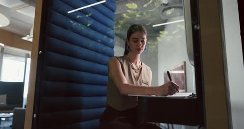 Business, woman and writing in office pod for story planning, editor feedback and creative process