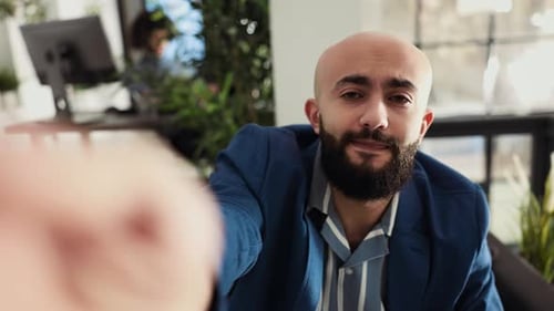 Man in Blue Suit Speaks to Camera in Office
