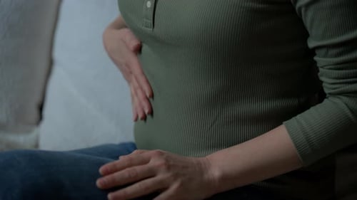 Closeup of a Person Holding Their Stomach Showing Signs of Abdominal Pain or Discomfort Health