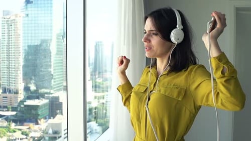 Happy Woman Dancing and Listening Music at Home