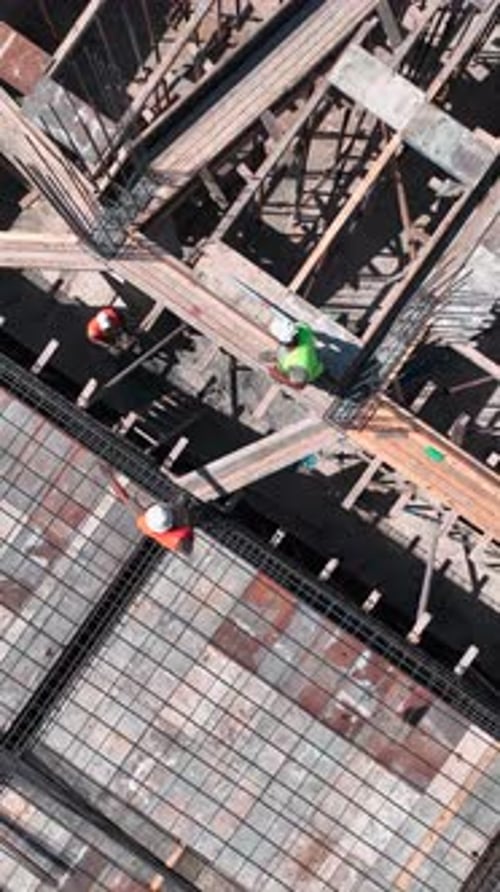 Vídeo vertical sobre la construcción de viviendas costeras con ingenieros y constructores que preparan el vertido de concreto para
