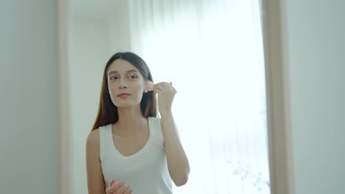 Woman Using Rose Quartz Facial Massager in Home