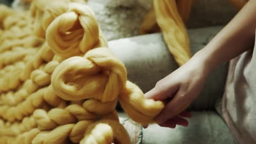 Woman Crafts Chunky Knit Blanket at Home
