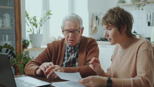 Hombre Anciano Pagando Cuentas en Línea con la Ayuda de su Nieta en Casa