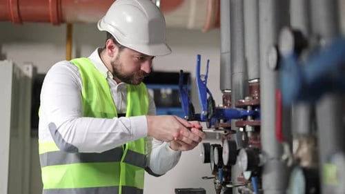 Engineer Works on Industrial Pipes with Gauges
