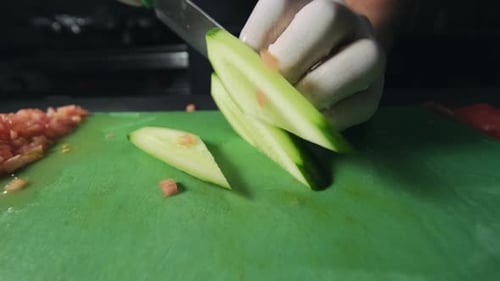 A male chef in a black uniform and a black apron in the restaurant kitchen. Preparing food. The cook
