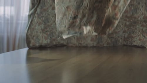 Woman Arranges Patterned Fabric on a Wooden Table