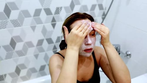 Woman Applying Facial Mask in Bathroom Close Up
