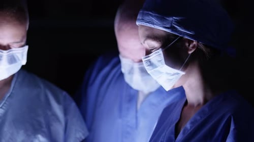 Surgeon focused intently performing delicate surgery in hospital operating room