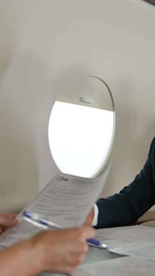 Adults Go Over Paperwork in a Private Jet