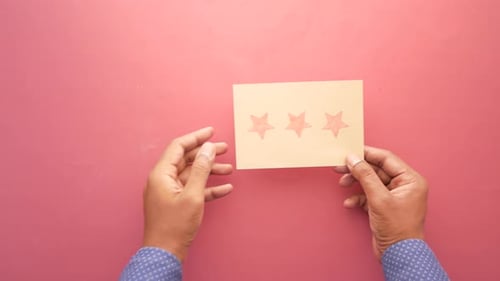 Customer Review Concept Rating Golden Stars on a Paper on Red Background