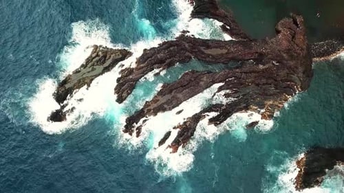 Aerial Drone View of Turquoise Ocean Waves Crashing Against Rocks