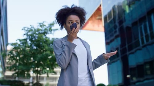 Young Woman Talking on Phone in Front of Office