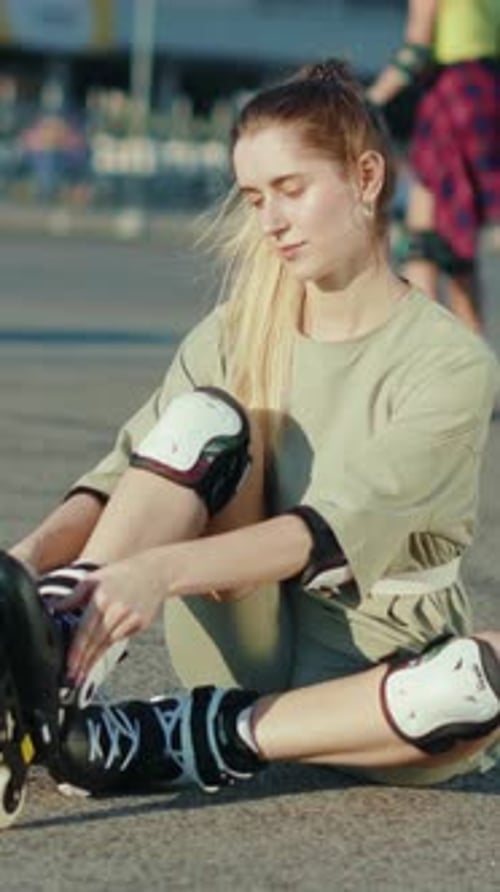 Woman Putting on Roller Blades Outdoors