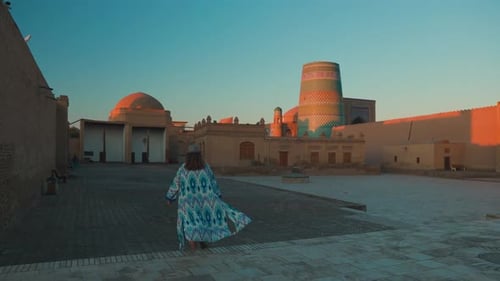 Touriste en costume ethnique près de Kalta Minar à Ichan Kala de Khiva