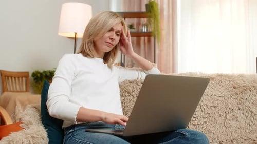 Woman Working on Laptop at Home Massages Temples