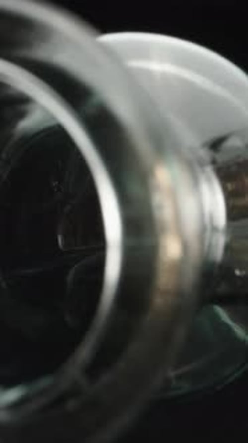 Macro video of a glass bottle. Dolly slider inside a water bottle close-up, rotation. Laowa Probe Ve