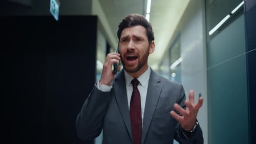 Man in Suit Talking on Phone in Office Hallway