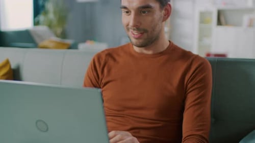Man Using Laptop Computer on Couch at Home