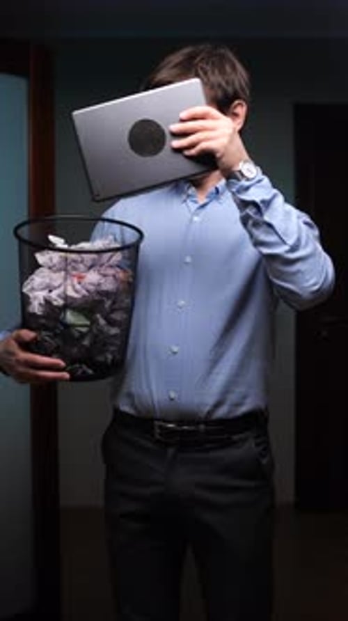 Vertical Video Businessman Throwing Laptop in Trash Can at Office