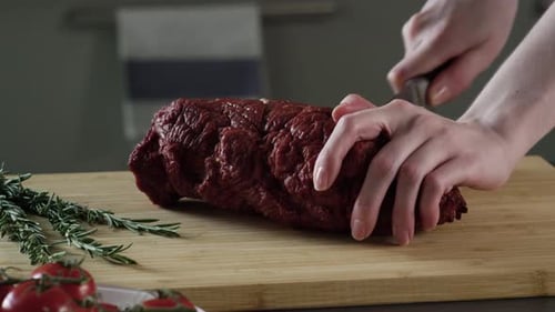 Hands Cutting Raw Beef Roast