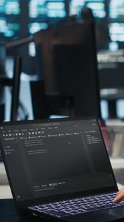 Vertical Video Computer Scientist Overseeing Data Center Servers Typing Code on Laptop