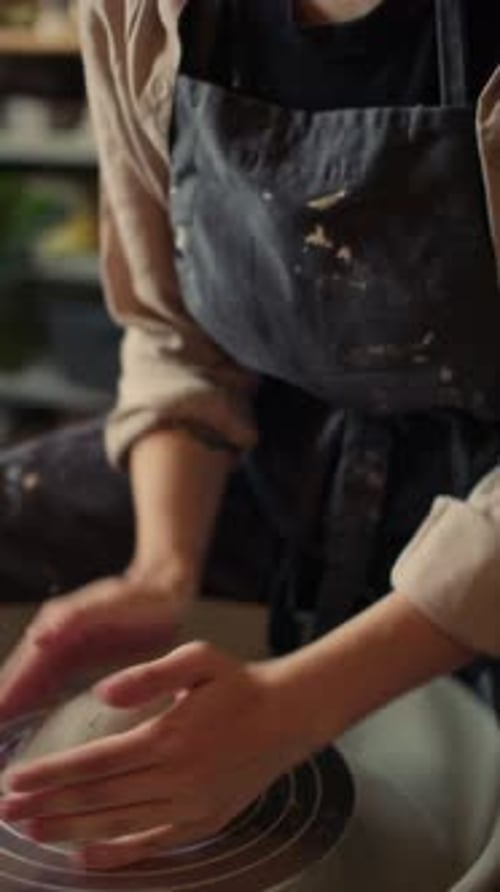 Woman Shaping Clay on Pottery Wheel in Studio