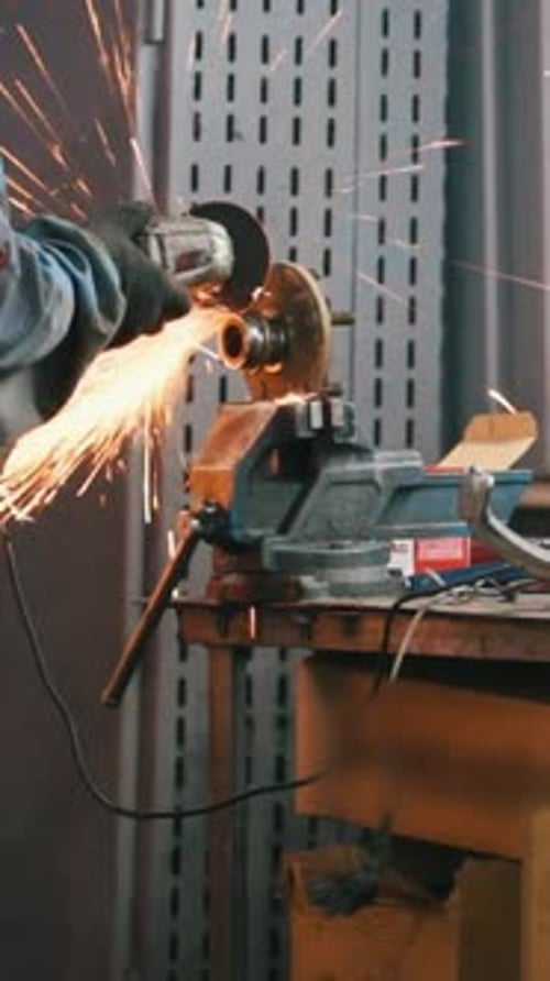 Car Auto Service Worker Grinding Metal Construction with a Circular