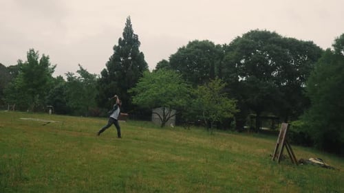 Male training for Axe throwing competition in green natural park, throwing ax at a target