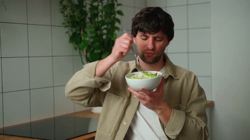Young Man Enjoying a Delicious Salad at Home