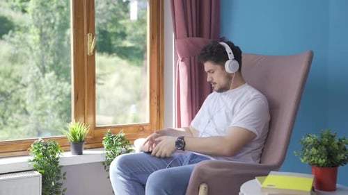 Young Adult Relaxing, Listening to Music at Home