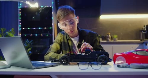 Smart Kid Assembling and Testing Electric Circuit Building and Programming Car. Boy Repairing