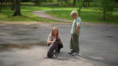 Woman Smiling With Dog And Child Nearby Happy Woman With Dog And Boy On Rainy Street Smiling Woman