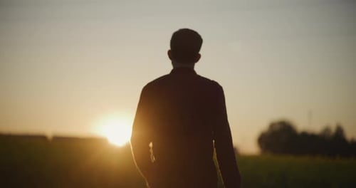 Person Silhouette Standing in a Field at Sunset