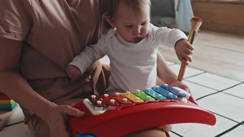 Baby Playing Xylophone on Lap with Adult